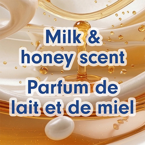Close-up abstract view of rich golden honey droplets mixing with smooth white milk cream. Text: "Milk & honey scent / Parfum de lait et de miel".