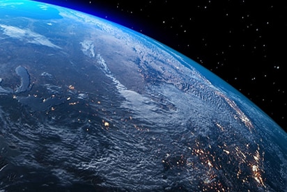 Image de la Terre vue de l'espace, montrant les continents illuminés la nuit.