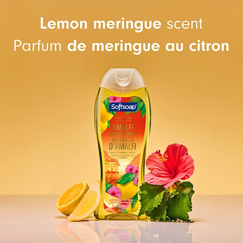 Une bouteille de gel douche Softsoap Amalfi Orchards, centrée entre des tranches de citron et une fleur d'hibiscus rose vif. Le texte au-dessus indique « Lemon meringue scent » et « Parfum de meringue au citron ».
