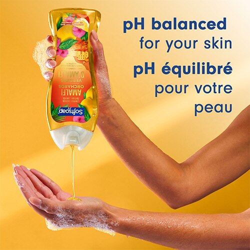 Sur un fond jaune chaud, une personne verse le gel douche jaune doré du flacon dans sa main. On peut lire : « pH équilibré pour votre peau ».