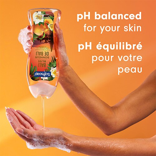 Une personne verse un gel douche doré dans sa main. Le texte en anglais et en français indique : pH équilibré pour votre peau.