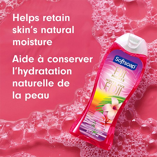 Le flacon Fiji Nights est présenté incliné sur un fond rose vif recouvert de mousse savonneuse. On peut lire sur le texte : « Aide à conserver l’hydratation naturelle de la peau ».