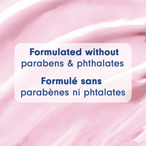 Gros plan sur la texture crémeuse et rose d'un nettoyant corporel. Le texte, en anglais et en français, indique : Formulé sans parabènes ni phtalates.