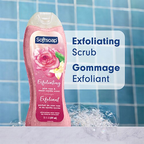 Une bouteille de 20 onces de gel douche exfoliant Softsoap, au parfum Rose rose et Vanille douce, présentée sur un fond de carrelage bleu. Un grand texte sur la droite indique « Exfoliating Scrub » en anglais et « Gommage Exfoliant » en français.