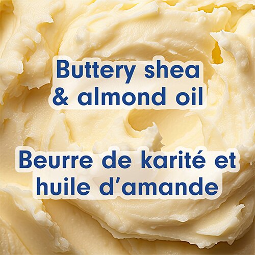 Gros plan sur la texture épaisse et fouettée d'un beurre de karité de couleur ivoire. Texte en anglais et en français : Buttery shea & almond oil, Beurre de karité et huile d’amande.