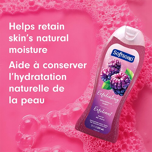 Bouteille de savon Softsoap Blackberry Sugar posée dans une eau savonneuse rose vif et mousseuse. Le texte superposé indique : « Aide à conserver l’hydratation naturelle de la peau ».