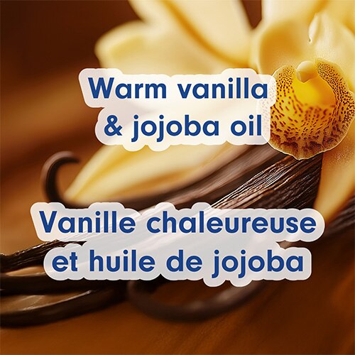Un gros plan macro d'une fleur d'orchidée jaune et de gousses de vanille foncées. Des superpositions de texte indiquent : « Warm vanilla & jojoba oil » et « Vanille chaleureuse et huile de jojoba ».