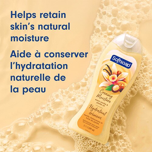 Le flacon d’huile de vanille chaude et de jojoba est incliné sur un fond jaune doré chaud recouvert de mousse savonneuse. On peut lire sur le texte : « Aide à conserver l’hydratation naturelle de la peau ».