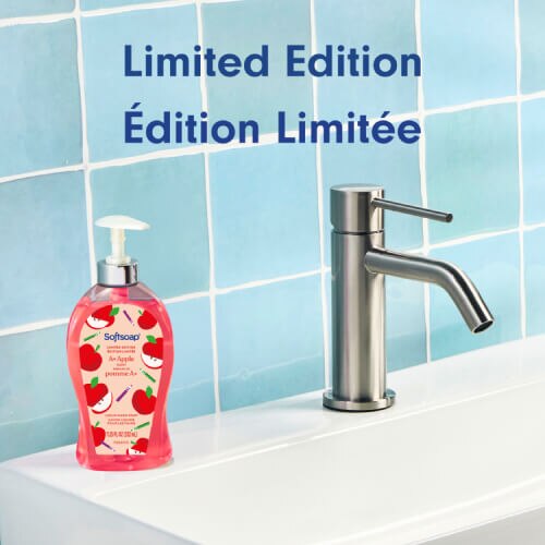 Un flacon de savon liquide pour les mains Softsoap A+ Apple est posé sur un lavabo de salle de bain blanc, à côté d'un robinet argenté moderne. Un grand texte situé au-dessus indique « Édition limitée », en anglais et en français.